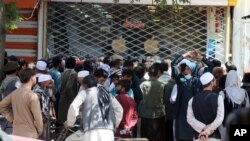 Afghans wait for hours to try to withdraw money, in front of Kabul Bank, in Kabul, Afghanistan, Saturday, Aug. 28, 2021. (AP Photo/Khwaja Tawfiq Sediqi)