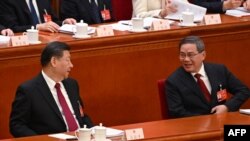 2024年3月5日，中国国务院总理李强（右）在中国人大开幕式上做完工作报告后与中国国家主席习近平（左）交谈。