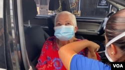 Una anciana es inoculada contra COVID-19 en medio de la pandemia del nuevo coronavirus, en Costa Rica. [Foto Archivo ].