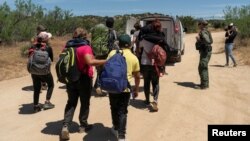 Migrantes suben a un auto para ser transportados a un área de estacionamiento, después de que el presidente estadounidense Joe Biden anunciara un amplio esfuerzo de aplicación de la seguridad fronteriza, en Jacumba Hot Springs, California, Estados Unidos, el 10 de junio de 2024.