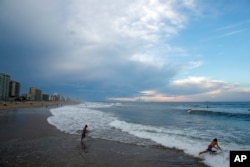 Surfers aprovechan las olas en Virginia Beach, Virginia, el 11 de septiembre de 2018, antes de la llegada del huracán Florence.