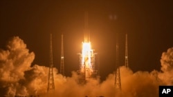 FILE - In this Nov. 24, 2020, photo, a Long March-5 rocket carrying the Chang'e 5 lunar mission lifts off at the Wenchang Space Launch Center in Wenchang in southern China's Hainan Province.