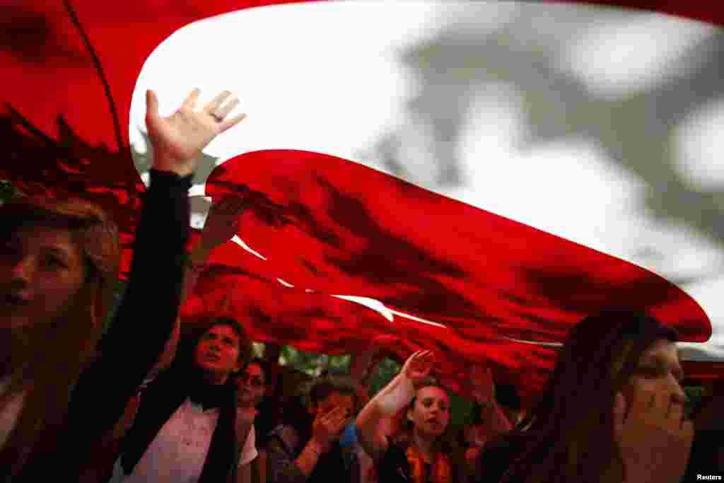 Protesters carry the Turkish flag and shout anti-government slogans during a demonstration at Gezi Park near Taksim Squar, Istanbul, June 3, 2013. 
