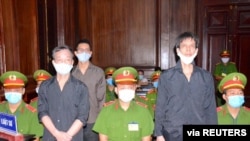 Les journalistes indépendants de l'Association des journalistes indépendants du Vietnam Pham Chi Dung, à droite, Le Huu Minh Tuan, au centre, et Nguyen Tuong Thuy se présentent lors de leur procès le 5 janvier 2021.