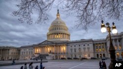 People walk by the U.S. Capitol in Washington, Jan. 21, 2018.