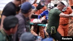 A rescue team carries a wounded worker at a collapsed building in Sihanoukville, Cambodia, June 22, 2019. 