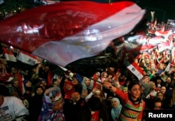 FILE - Supporters of Egypt's army and police gather at Tahrir Square in Cairo, on the third anniversary of Egypt's uprising, Jan. 25, 2014. The government, wary of new protests, tightened security in Cairo.