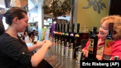 FILE - In this July 25, 2011, a woman tastes high-end olive oil tasting in Napa, California. Olive oil production in the U.S. has been steadily growing. (AP Photo/Eric Risberg)