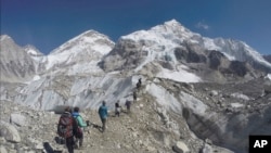 FILE - Climbers pass through a glacier at the Mount Everest base camp, Nepal, Feb. 22, 2016.