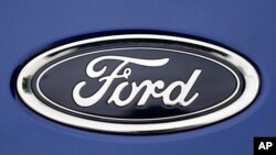 FILE - In this Aug. 22, 2017 file photo, a Ford emblem is seen on a car at a store in London.