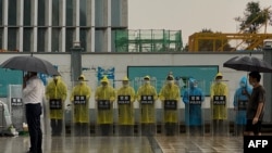 位於深圳的恆大集團總部外警察穿著雨衣在站崗。 （2021年9月14日）