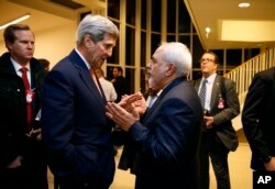 FILE - Secretary of State John Kerry talks with Iranian Foreign Minister Mohammad Javad Zarif in Vienna, after the International Atomic Energy Agency (IAEA) verified that Iran has met all conditions under the nuclear deal.