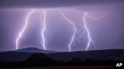 In this photo taken Wednesday, Aug. 9, 2017 a strike of lightning illuminates the sky over Annaberg-Buchholzer, southeastern Germany. (Bernd Maerz/dpa via AP)