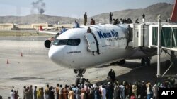 Afganistanci oko i na avionu na aerodromu Hamid Karzai u Kabulu (Foto: AFP)