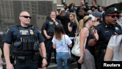 FILE - Family members of detainees line up to enter the federal court just before a hearing to consider a class-action lawsuit filed on behalf of Iraqi nationals facing deportation, in Detroit, Mich., June 21, 2017.
