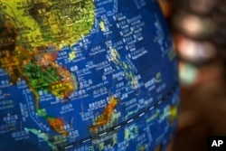 In this July 13, 2018, photo, a globe shows the islands on the South China Sea with nine-dash line claims under Chinese territory on display at a bookstore in Beijing.
