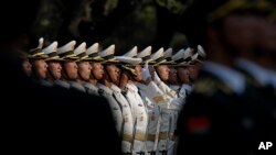 資料照片：一名中國人民解放軍士兵正在調整儀仗隊成員的帽子 （2016年4月12日，美聯社照片）