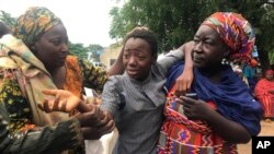 Mwanafunzi aliyekuwa ameweka na kuachiwa huru akiungana na familia yake katika Shule ya Sekondari ya Juu ya Bethel Baptist huko Damishi, Nigeria, Jumapili, Julai 25, 2021. (AP Photo).