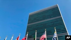 FILE - Flags fly outside the United Nations headquarters during the 74th session of the United Nations General Assembly, Sept. 28, 2019.