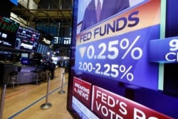 FILE - A television monitor on the floor of the New York Stock Exchange headlines a rate decision of the Federal Reserve, in New York, July 31, 2019.