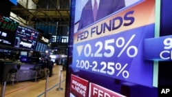 FILE - A television monitor on the floor of the New York Stock Exchange headlines a rate decision of the Federal Reserve, in New York, July 31, 2019. 