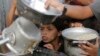Un niño palestino observa mientras le sirven una ración de comida antes de la fiesta del Eid al-Adha, en Jan Yunis, Gaza, el 15 de junio de 2024. 