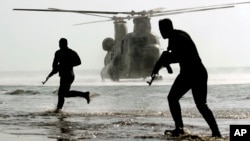 资料照片：伊朗军队2021年1月19日公布的照片显示伊朗军人在阿曼湾海岸进行演习。