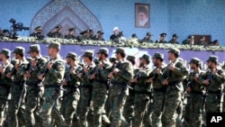 FILE - Iran's President Hassan Rouhani, top center, reviews army troops marching during the 37th anniversary of Iraq's 1980 invasion of Iran, in front of the shrine of the late revolutionary founder, Ayatollah Khomeini, just outside Tehran, Iran.