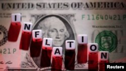 FILE PHOTO: Illustration shows plastic letters arranged to read "Inflation" are placed on U.S. dollar banknote