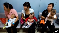 在為農民工提供母嬰檢查的北京朝陽區十八里店鄉醫院，中國婦女抱著孩子等著看醫生。 （2007年9月5日資料照）