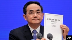Xu Lin, Vice head of the Publicity Department of Communist Party, shows a copy of the white paper on fighting COVID-19 China during a press conference at the State Council Information Office in Beijing, June 7, 2020.