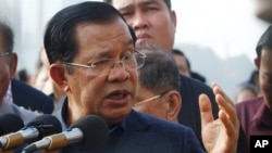 FILE - Cambodia's Prime Minister Hun Sen delivers a speech to passengers after they disembarked from the MS Westerdam, owned by Holland America Line, at the port of Sihanoukville, Cambodia, Friday, Feb. 14, 2020.