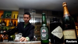 Bottles of alcoholic drinks are displayed on a counter whilst a waiter pours an alcoholic drink into a glass at a bar in Dubai March 9, 2011.