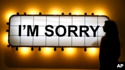 A Sotheby's employee looks at an artwork by Adel Abidin called 'I'm Sorry' at Sotheby's auction rooms in London, Friday, April 15, 2016. New research suggests that saying sorry when you reject someone in a social situation does more harm than good. (AP Photo/Kirsty Wigglesworth)