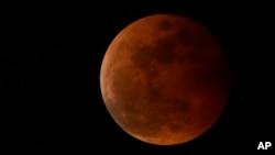 ARCHIVO - La luna sale durante un eclipse lunar en el área metropolitana de Manila, Filipinas, el 8 de noviembre de 2022. Un evento similar ocurrirá el 13 de marzo de 2025.