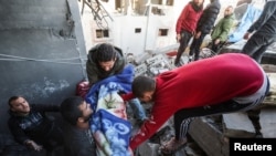 Palestinians carry the dead body of a child, at the site of an Israeli strike on a house in Nuseirat, in the central Gaza Strip, Jan. 9, 2025, amid the ongoing conflict between Israel and Hamas.