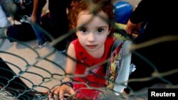 بیروت میں شام کے پناہ گزینوں کے ایک کیمپ میں ایک بچی کھانے پینے کی چیزیں ملنے کا انتظار کر رہی ہے۔ ستمبر 2018