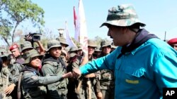 In this handout photo released by Miraflores Press Office, Venezuela's President Nicolas Maduro fist bumps with a cadet at the G/J José Laurencio Silva military training center in the state of Cojedes, Venezuela, May 4, 2019.