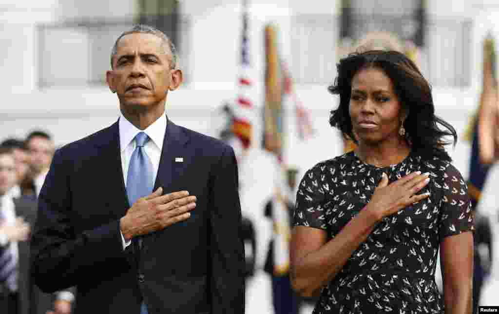 President Barack Obama and First Lady Michelle Obama observe a moment of silence on the 13th anniversary of the 9/11 attacks at the White House, in Washington, Sept. 11, 2014.