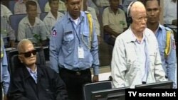 អតីត​មេដឹកនាំ​ខ្មែរ​ក្រហម នួន ជា ​និង​ខៀវ សំផន​ នៅ​ក្នុង​អំឡុង​សវនាការ​កាល​ពី​ថ្ងៃ​ទី​៧ ខែ​សីហា ឆ្នាំ​២០១៤។