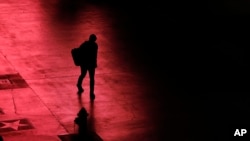 Osoba hoda praznim centrom Las Vegasa posle zatvaranja kockarnica zbog pandemije, 18. marta 2020. (Foto: AP/John Locher)