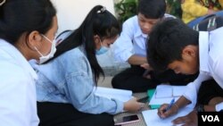 រូបឯកសារ៖ សិស្សានុសិស្ស​​កំពុង​អង្គុយ​មើល​មេរៀន​ក្នុង​ម៉ោង​សម្រាក អំឡុង​ការ​ប្រឡង​បាក់ឌុប នៅ​ថ្ងៃទី​២៧ ខែ​ធ្នូ ឆ្នាំ​២០២១។ (កាន់ វិច្ឆិកា/វីអូអេ)