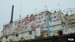 The Apung 1 barge, which was generating electricity offshore, was carried five kilometers by the tsunami and came to rest atop two houses. (Steve Herman/VOA News)