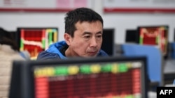 中國安徽省阜陽市的一名投資人正在查看顯示股市走勢。（2024年1月17日）