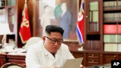 En esta foto sin fecha facilitada por el gobierno de Corea del Norte el domingo 23 de junio de 2019, el gobernante norcoreano Kim Jong Un lee una carta del mandatario estadounidense Donald Trump. 