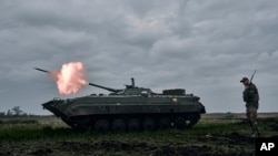 Український БТР веде вогонь по російських позиціях біля Авдіївки в Донецькій області, Україна. AP Photo/Libkos