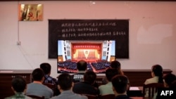 資料照片：廣西柳州一個村莊的村民正在觀看在北京人大會堂舉行的全國脫貧攻堅總結表彰大會的電視直播。（2021年2月25日）