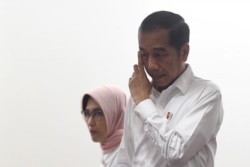 Indonesian President Joko Widodo arrives with Sripeni Inten Cahyani, PLN's acting CEO, during a visit at PT Perusahaan Listrik Negara (PLN) headquarters, after a power blackout in Jakarta, Indonesia, Aug. 5, 2019. (Antara Foto/Akbar Nugroho Gumay)
