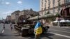 Un hombre que porta una bandera ucraniana visita una avenida donde se exhiben vehículos militares rusos destruidos antes del Día de la Independencia en Kiev, Ucrania, el lunes 21 de agosto de 2023. [Foto: Archivo/AP]