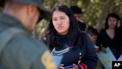 Una migrante de México habla con un agente de la Patrulla Fronteriza poco antes de ser transportada en una camioneta para ser procesada para el asilo, el miércoles 5 de junio de 2024, cerca de Dulzura, California, EEUU. 